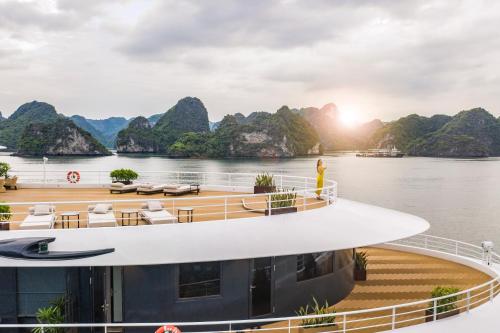 下龙湾Sea Stars Cruise Ha Long Bay的一艘船在水面上,背景是群山