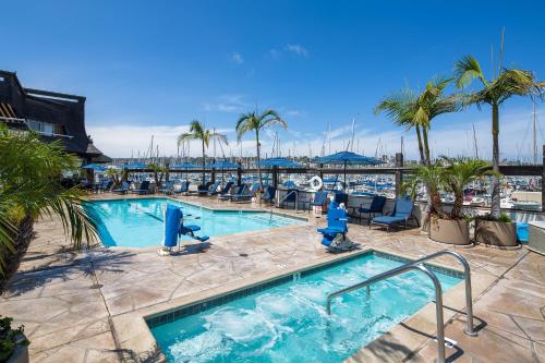 圣地亚哥海湾俱乐部酒店和码头的一个带椅子和棕榈树的游泳池,一个码头