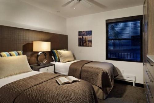 阿斯潘Luxury 3 Bedroom Downtown Aspen Vacation Rental With Amenities Including Heated Pool, Hot Tubs, Game Room And Spa的酒店客房设有两张床和窗户。