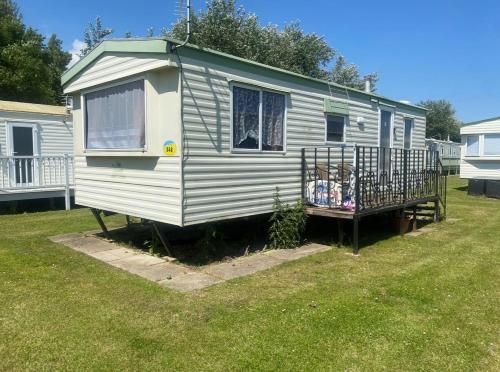 英戈尔德梅尔斯Affordable family caravan PROMENADE的一个小房子正坐在院子里