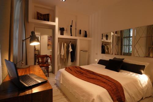 米兰伊索拉利伯拉旅馆的一间卧室配有一张床和一张桌子上的笔记本电脑