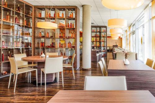 腓特烈港宜必思腓特烈港机场展览馆酒店的一间带桌椅和罐子架的餐厅