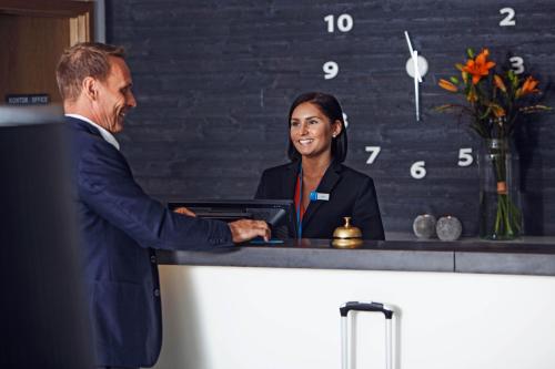 斯德哥尔摩斯德哥尔摩天空酒店式公寓的男人和女人握手在柜台