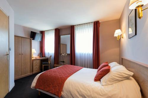 圣布里厄圣布里厄克利松酒店的配有一张床和一张书桌的酒店客房
