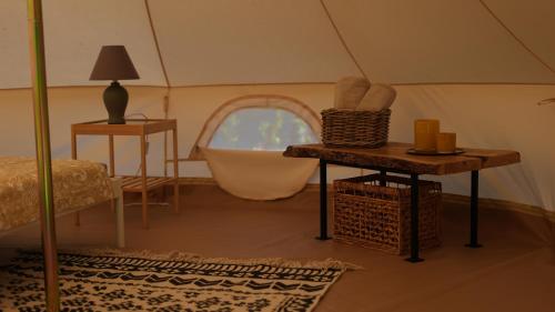 Sicignano degli AlburniGlamping Di Palma的一间设有浴缸和一张位于帐篷内的床铺的房间