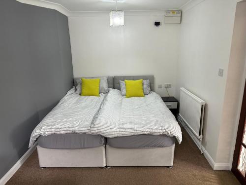 卢顿Luton City Escape - Modern 1BR Apartment的一间卧室配有一张带两个黄色枕头的床