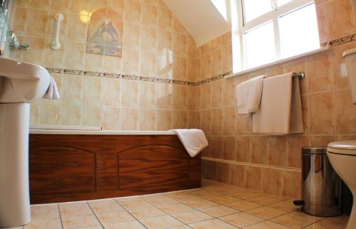 特拉利肯内斯库拉恩酒店的带浴缸和盥洗盆的浴室