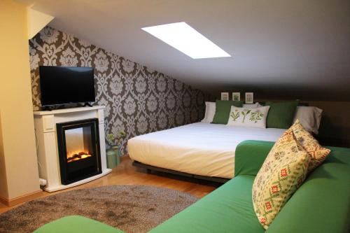 纳赫拉Apartamentos Vino y Camino的一间卧室设有一张床和一个壁炉,配有电视