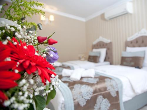 伯萨卡迪肯纳吉温泉酒店的一间酒店客房,配有一张床和一束鲜花