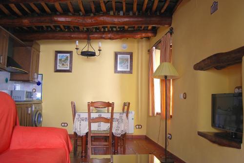布维翁Casa El Rincón del Ángel的一间带桌子的客厅和一间带电视的厨房
