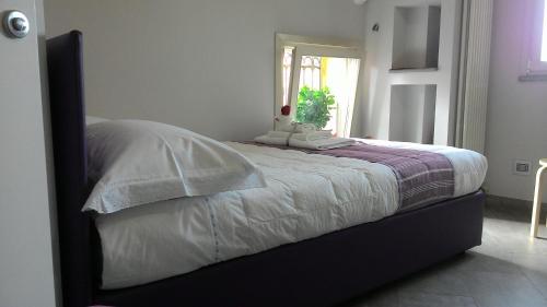 都灵曼萨达帕拉提公寓的一间卧室配有一张带白色床单的床和一扇窗户。