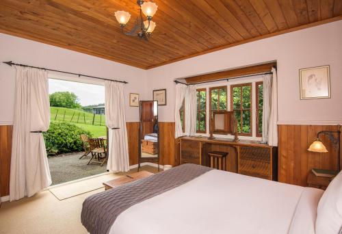 Waimauku库姆葡萄园酒店的一间卧室设有一张床和一个窗口