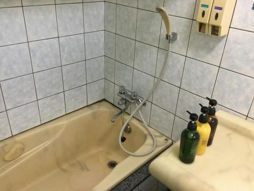 西表岛乌纳里扎奇别墅的浴室配有带瓶子的浴缸。