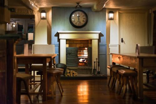 兰卡斯特芬威克牛排和海鲜酒吧宾馆的一间设有壁炉的客房,墙上挂着一个钟