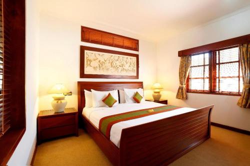 沙努尔沙努尔阿佩尔别墅酒店的一间卧室设有一张大床和两个窗户。