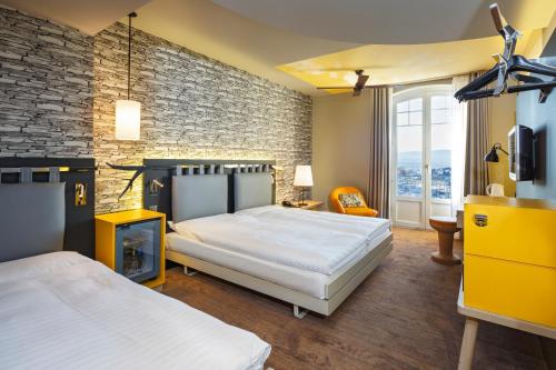 洛桑法斯宾德瑞士葡萄酒酒店的一间卧室设有两张床和砖墙