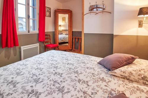 贝叶法国最小的房子度假屋的一间卧室配有床和红色窗帘