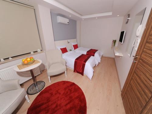 伊斯坦布尔市中心加泽尔公寓式酒店的酒店客房,配有床和红色地毯