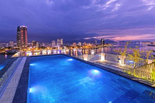 岘港IBIZA Riverfront Da Nang Hotel Powered by ASTON的一座城市天际线建筑的顶部游泳池