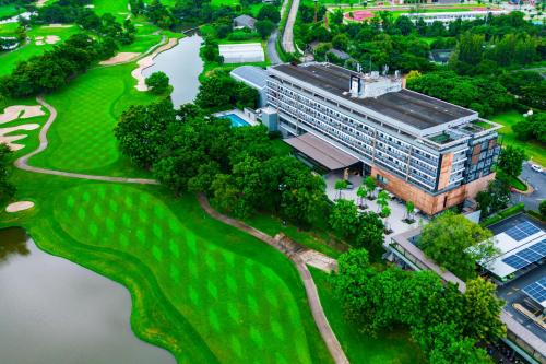 巴吞他尼Tinidee Hotel Bangkok Golf Club - SHA Certified的高尔夫球场上建筑物的空中景观