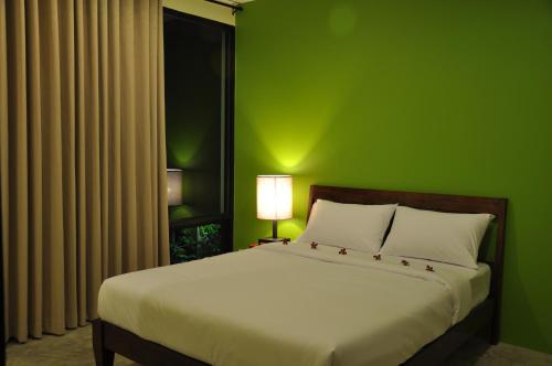 曼谷优迪曼谷旅舍的绿色卧室,配有一张带绿色墙壁的床