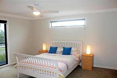 因沃洛什Stylish Living- Fireplace, WiFi, Linen, 4 bdrm, Beach 850m的卧室配有带蓝色枕头的白色婴儿床