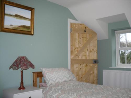 ClogherThe Homecoming Barn的一间卧室配有一张床和一扇木门