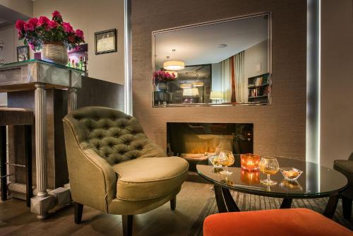 巴黎哈维酒店的客厅配有椅子、桌子和壁炉