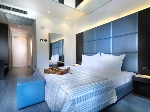 Novedrate布鲁9酒店的一间卧室配有一张白色大床和蓝色床头板