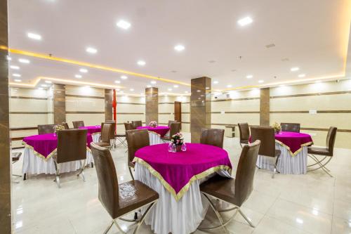 新德里Hotel Red Castle - Karol Bagh - Where luxury meets comfort的宴会厅配有紫色的桌椅