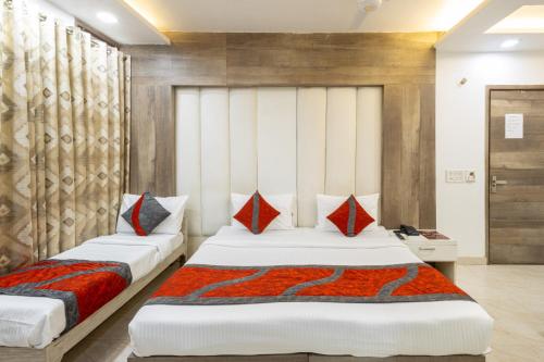 新德里Hotel Red Castle - Karol Bagh - Where luxury meets comfort的一间卧室配有两张带红色枕头的床