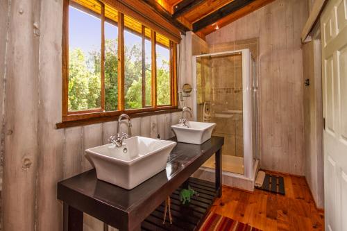 普利登堡湾皮赛因山谷小屋酒店的带窗户的浴室内的2个盥洗盆