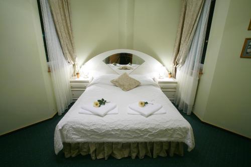 比亚韦斯托克泰坦尼克酒店的卧室配有带鲜花的白色床