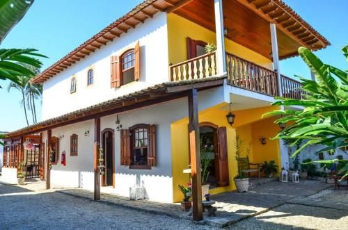 帕拉蒂Viva Brasil Pousada的黄色和白色的房子设有阳台