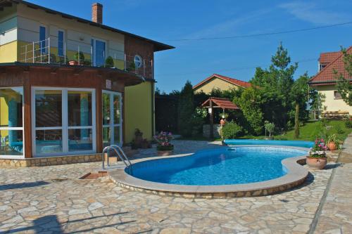 RábapatyGasthaus Joó-Wellness Pension的房屋前的游泳池