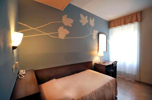 蒙法尔科内艾坎比迪马塞罗酒店的一间卧室配有一张床、一张书桌和一个窗户。