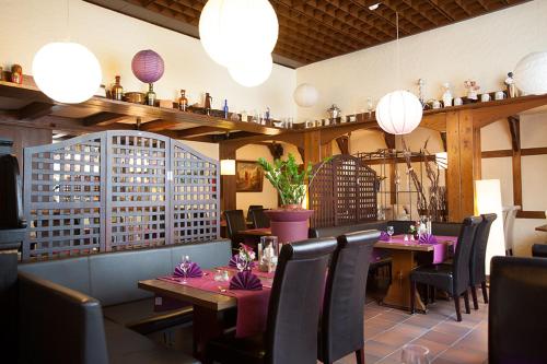 奥伯豪森豪斯友尼恩酒店的餐厅设有粉红色的桌椅和灯光