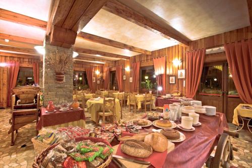 库马约尔阿索托丽亚酒店的一间大餐厅,配有餐桌和食物