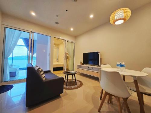 哥打京那巴鲁Summer Seaview Studio Apartment at Kota Kinabalu City Centre的客厅配有餐桌和电视