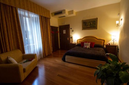 ForchiaCamere al Borgo的一间卧室配有一张床、一把椅子和一张沙发