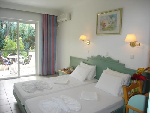 科斯镇安德洛墨达公寓式酒店的一间卧室配有一张带两条白色毛巾的床