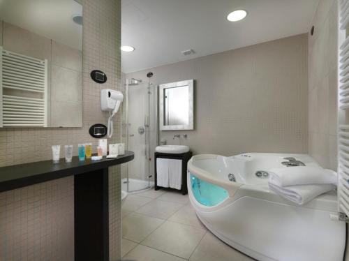 Novedrate布鲁9酒店的一间带大浴缸和淋浴的浴室