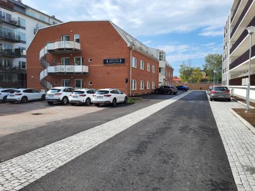 乌普萨拉Vandrarhem Uppsala - Portalgatan的砖砌建筑前的街道,有汽车停放