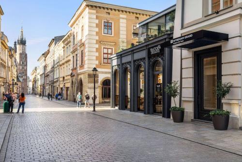 克拉科夫Wyndham Grand Krakow Old Town的街道上,有建筑和人走在街上