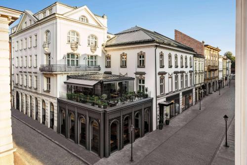 克拉科夫Wyndham Grand Krakow Old Town的一条拥有白色建筑和商店的城市街道