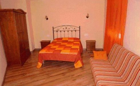 CabezabellosaAlojamiento rural la Bellosina的一间卧室配有一张可调节的床和一张沙发