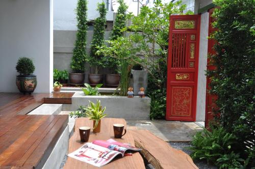 曼谷优迪曼谷旅舍的一个带红色门和木桌的庭院