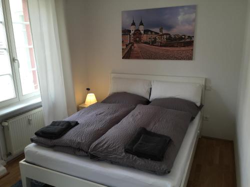 海德堡林赫尔岑德老城酒店的卧室内的一张床铺,墙上挂着一幅画