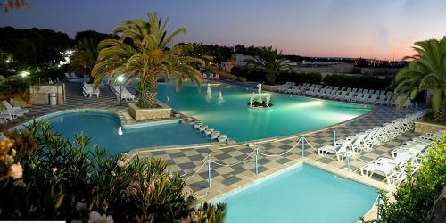 斯培基奥拉Camping Villaggio Pineta Al Mare的度假村内带白色椅子的大型游泳池