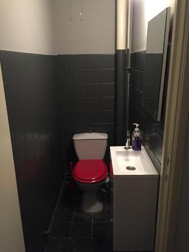 列日Studio Peralta的一间带红色卫生间和水槽的浴室